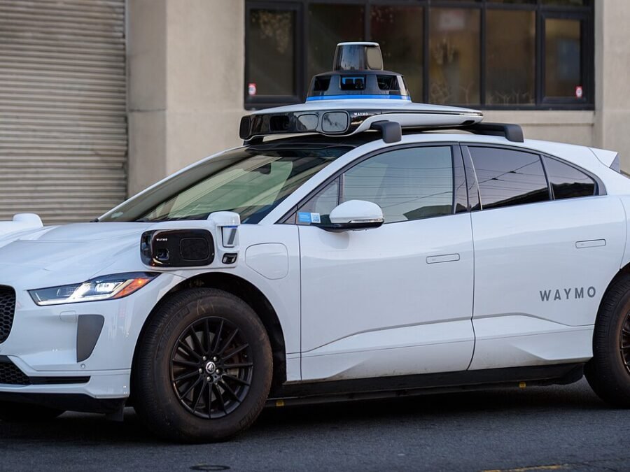 Waymo Jaguar I-PACE with autonomous-driving sensors — real San Francisco photograph used illustratively for the Munich expansion story