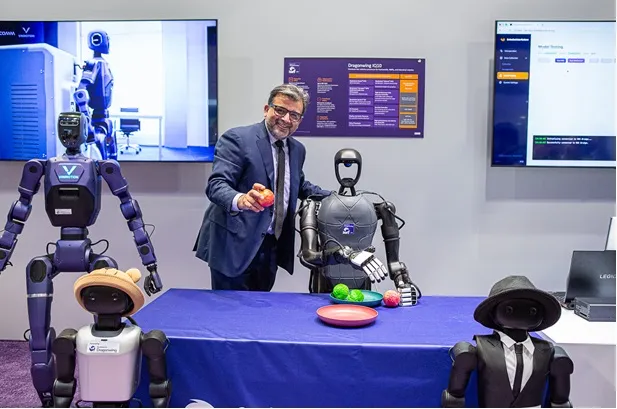 Qualcomm EVP Nakul Duggal with Dragonwing IQ10-based robots at CES 2026 — real photograph used illustratively