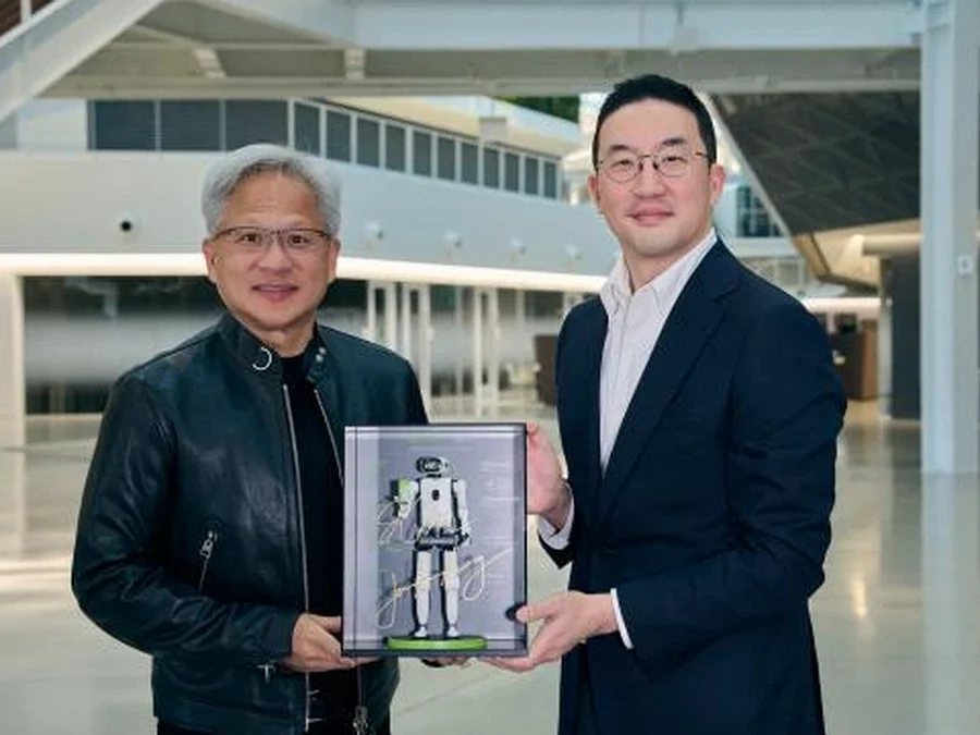 LG's Kwang Mo Koo and NVIDIA's Jensen Huang present a miniature humanoid model after signing their memorandum