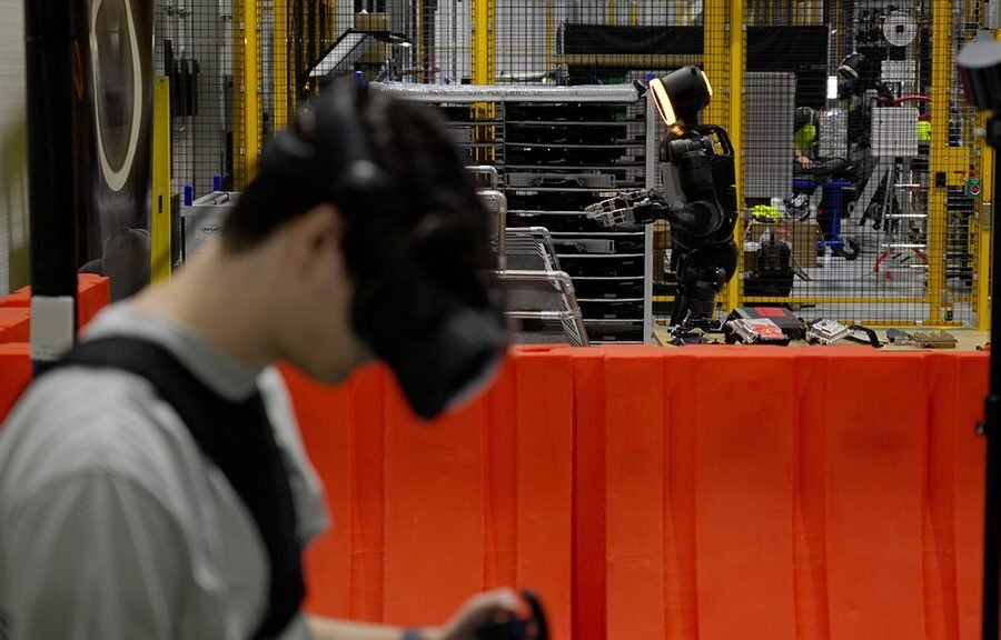 Operator z wyposażeniem treningowym i robot Atlas w centrum RMAC Boston Dynamics